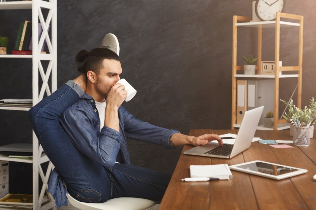 Flexible man practicing yoga at workplace