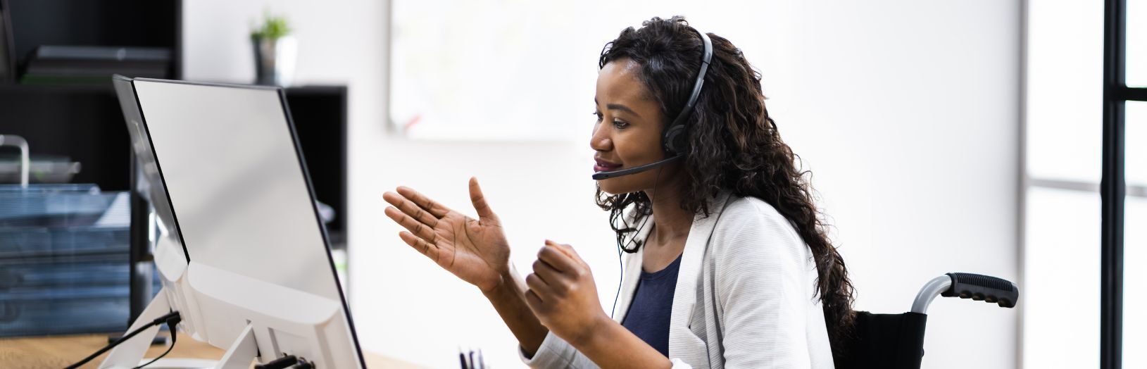 kvinde foran computer med headset