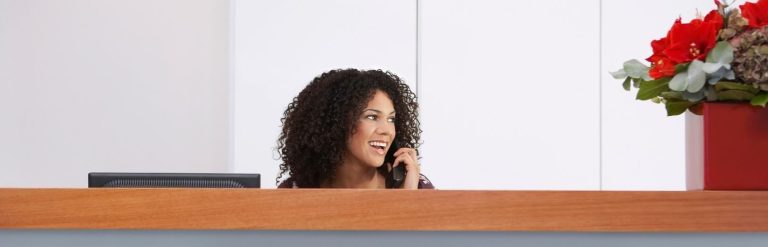 receptionist snakker i telefon