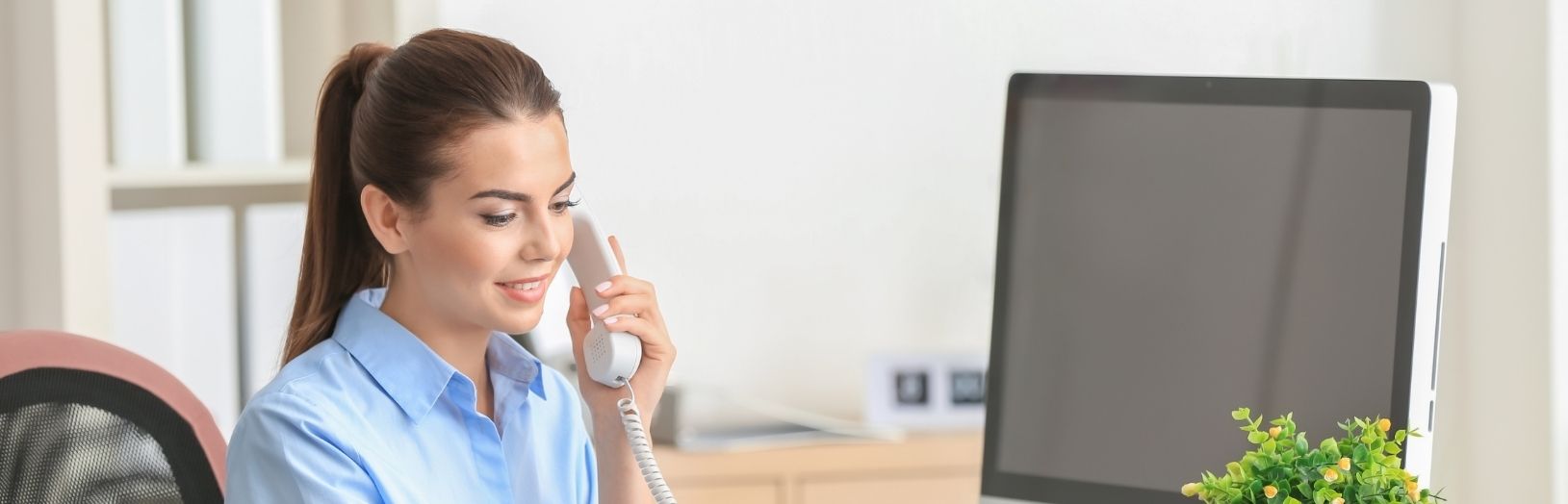 receptionist snakker i telefon