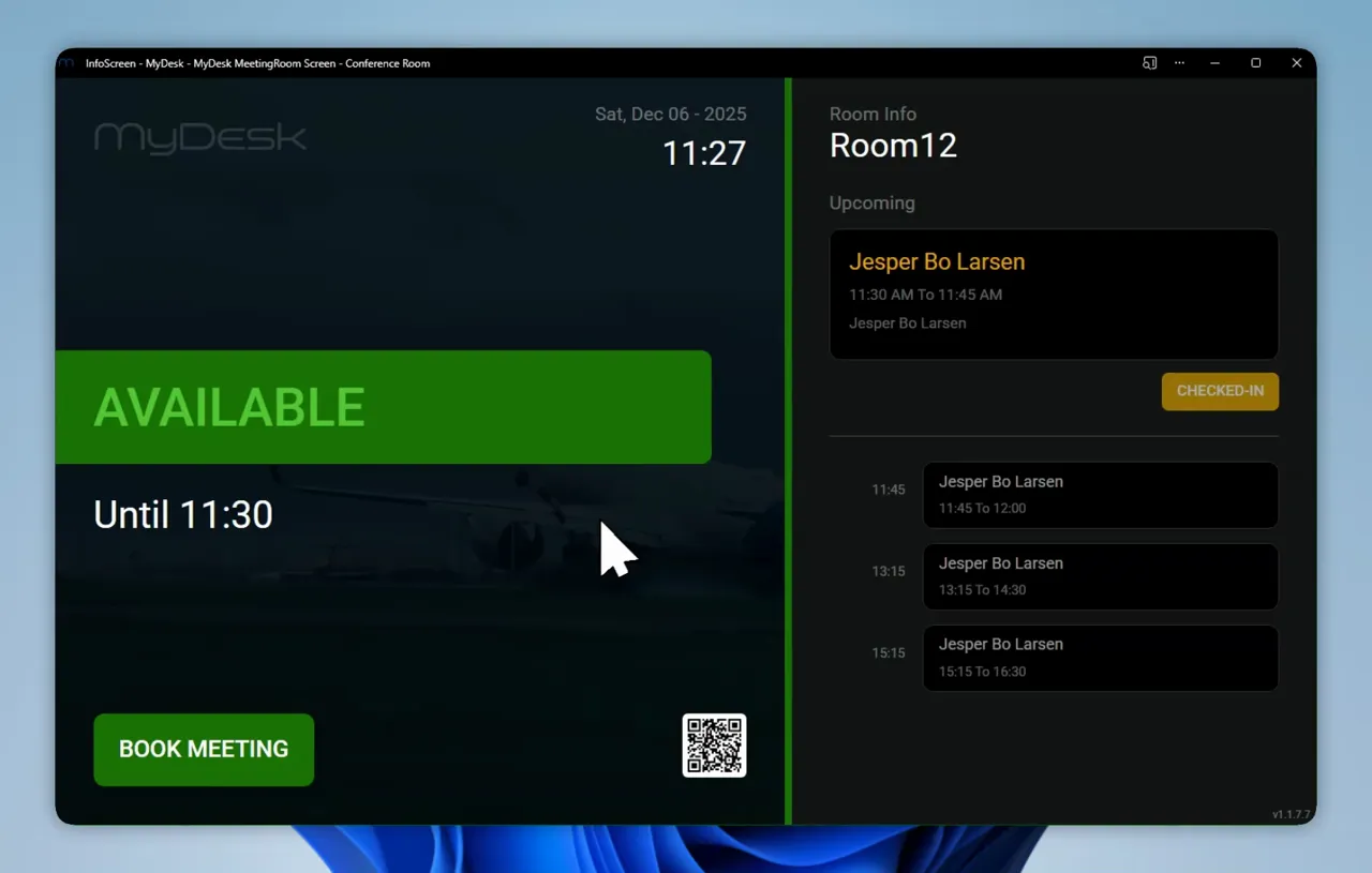 MyDesk meeting room display with background image of aircraft, 'Available' status and meeting overview on the right