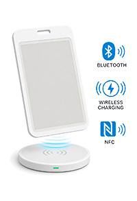 White wireless charging stand with a phone resting on it, glowing blue charging indicator; icons for Bluetooth, wireless charging, and NFC shown to the side.