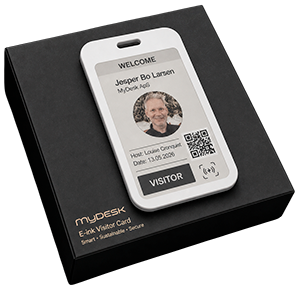 White visitor badge with photo, name, QR code, and a 'VISITOR' label on a dark MyDESK box, as a gift or check-in device.
